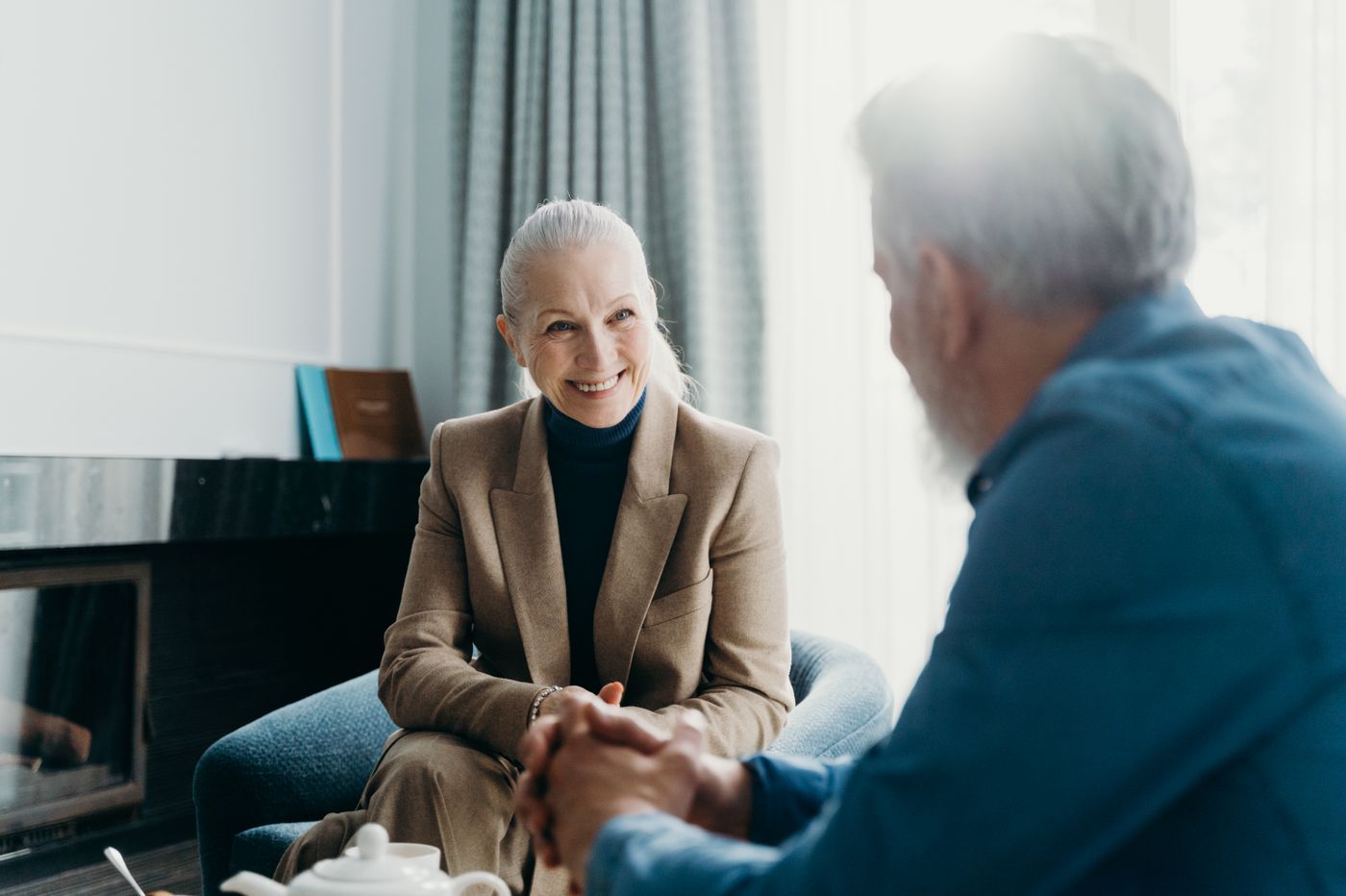 Two older adults talking and smiling in a bright room
